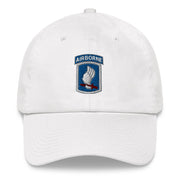 A white 173rd Airborne Brigade Hat with the logo on the front.  The hat has a curved visor and an adjustable strap at the back.