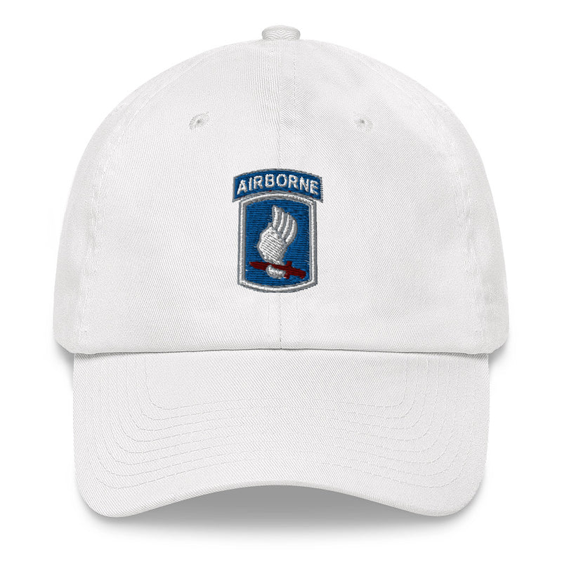 A white 173rd Airborne Brigade Hat with the logo on the front.  The hat has a curved visor and an adjustable strap at the back.