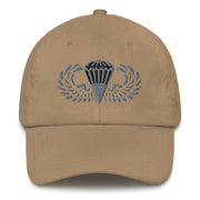 A khaki colored Basic Parachutist Hat with the logo on the front.  The hat has a curved visor and an adjustable strap at the back.