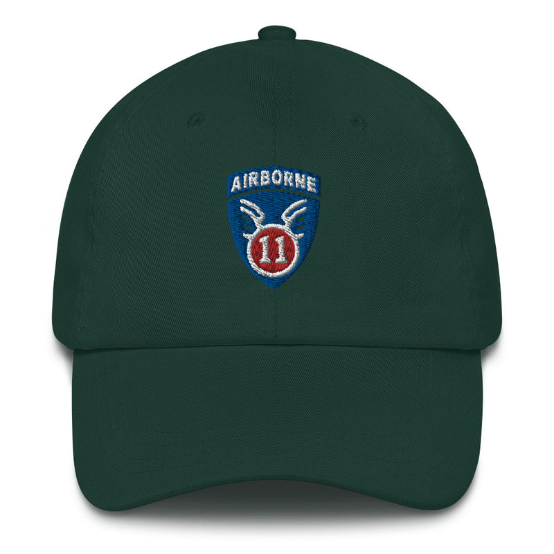 A spruce colored 11th Airborne Division Hat with the logo on the front.  The hat has a curved visor and an adjustable strap at the back.