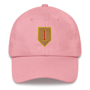A pink 1st Infantry Division Hat with the logo on the front.  The hat has a curved visor and an adjustable strap at the back.