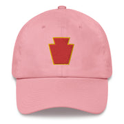 A pink 28th Infantry Division Hat with the logo on the front.  The hat has a curved visor and an adjustable strap at the back.