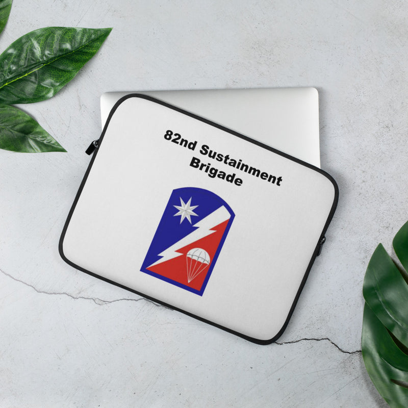 A lightweight and water-resistant white Laptop Sleeve with the 82nd Sustainment Brigade logo printed on top. The laptop sleeve is designed to fit a 13" laptop.