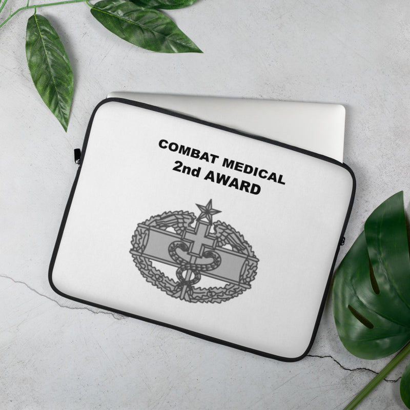 A lightweight and water-resistant white Laptop Sleeve with the Combat Medical 2nd Award logo printed on top. The laptop sleeve is designed to fit a 15" laptop.