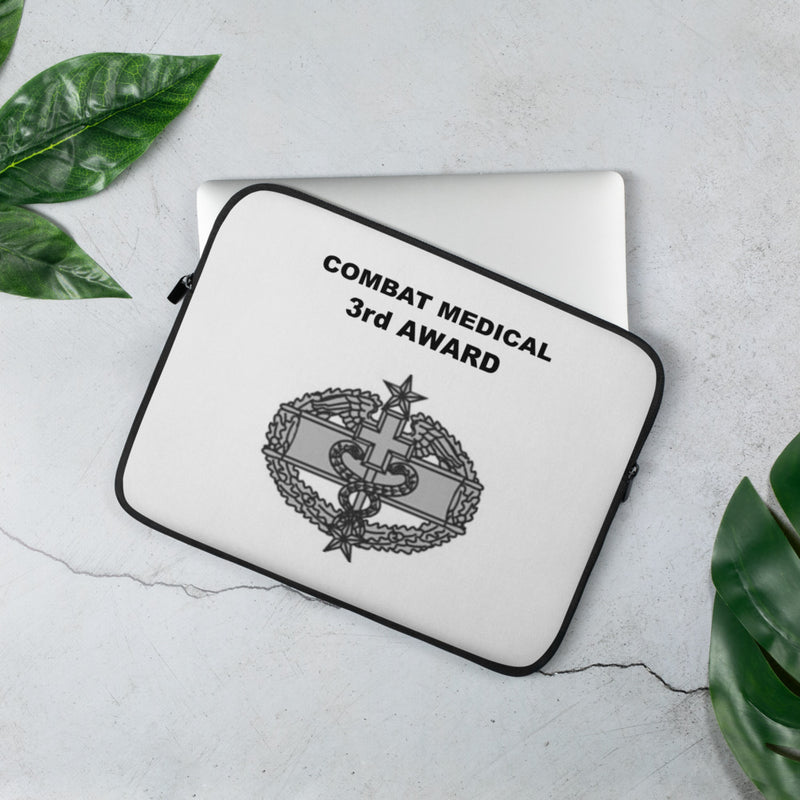 A lightweight and water-resistant white Laptop Sleeve with the Combat Medical 3rd Award logo printed on top. The laptop sleeve is designed to fit a 13" laptop.