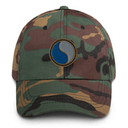 A military style 29th Infantry Division Hat with camouflage and the logo on the front.  The hat has a curved visor and an adjustable strap at the back. 