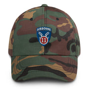 A military style 11th Airborne Division Hat with camouflage and the logo on the front.  The hat has a curved visor and an adjustable strap at the back. 