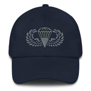 A navy blue Basic Parachutist Hat with the logo on the front.  The hat has a curved visor and an adjustable strap at the back.