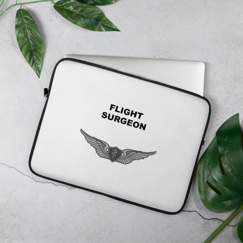 A lightweight and water-resistant white Laptop Sleeve with the Flight Surgeon logo printed on top. The laptop sleeve is designed to fit a 15" laptop.