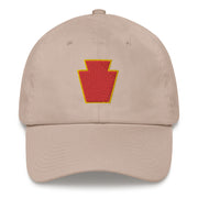 A stone colored 28th Infantry Division Hat with the logo on the front.  The hat has a curved visor and an adjustable strap at the back.